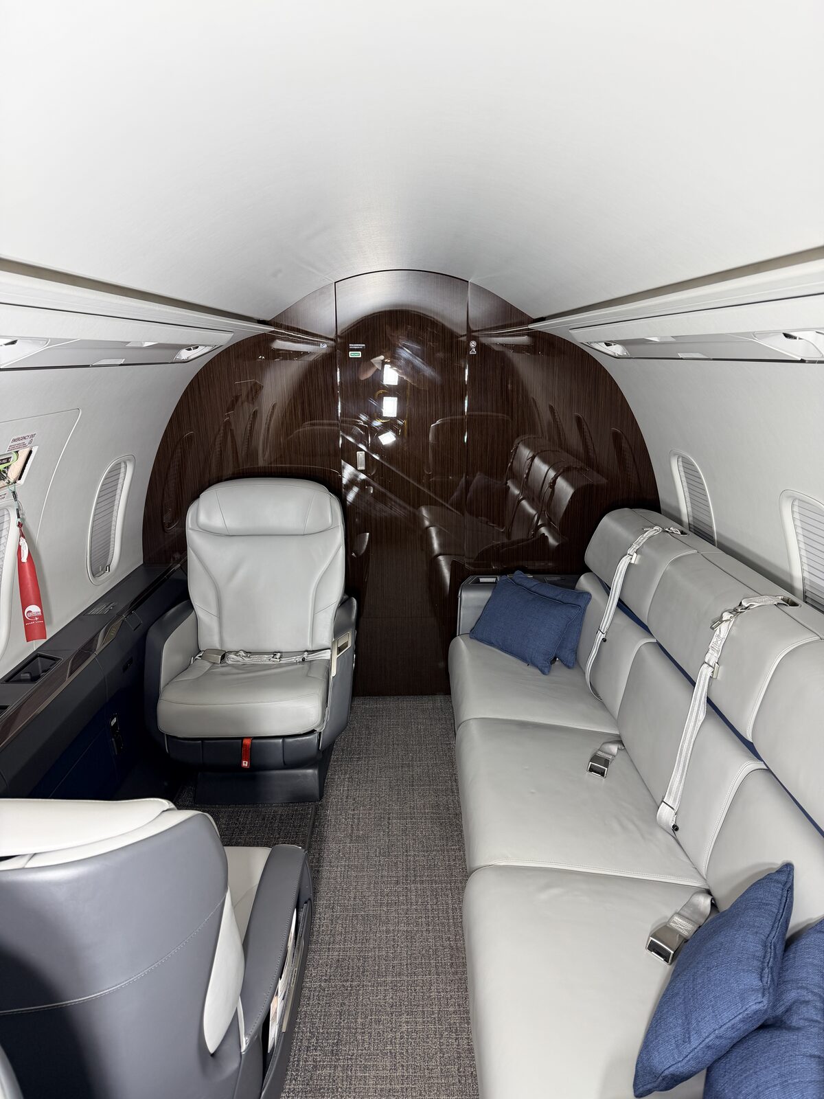 Bombardier Challenger 350 interior full cabin wide view divan blue pillows club seats wood tables